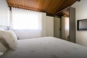 嘎林海斯港Bangalo Malawi em Muro Alto PE的卧室配有白色的床和窗户。
