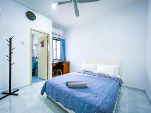 太平Tupai Mas Semi-D by LOUIS的一间卧室配有一张带蓝色棉被的床