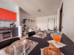 因佩里亚Appartamento Incantevole a 100metri dal mare e vicino a pista ciclabile的厨房配有带面包和玻璃杯的桌子