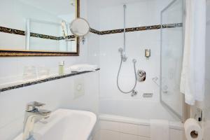 慕尼黑Hotel Aurbacher Hof GmbH的带淋浴和盥洗盆的白色浴室
