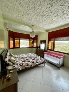 Plage de MehdiaMehdia Ville的卧室配有一张床、一张书桌和窗户。