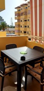 洛斯克里斯蒂亚诺斯Luminoso y bonito apartamento con piscina en frente del mar的阳台上配有一张黑色的桌子和椅子