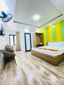 下龙湾Hùng Vương Hotel Hạ Long的一间卧室设有一张床和色彩缤纷的墙壁