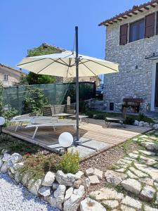 斯波莱托Alloggio turistico Montelirossi的一个带桌子和遮阳伞的庭院