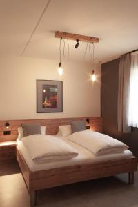 Eynatten泰康AG餐饮酒店的一间卧室配有一张带白色床单的大床