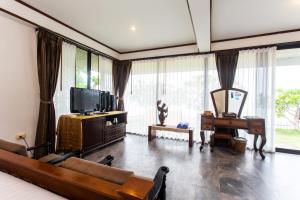 利巴诺伊Rajapruek Samui Resort - SHA Plus的带沙发、电视和钢琴的客厅