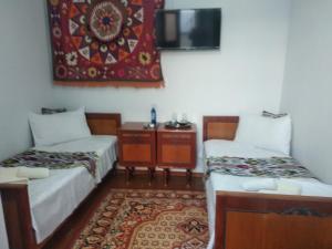 布哈拉Al-Bashir的小房间设有两张床和地毯