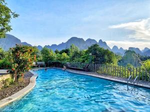 阳朔阳朔东岭别墅的一座蓝水游泳池,背景是群山