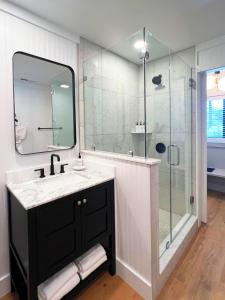 凯什尔斯Hotel Cashiers的浴室配有盥洗盆和带镜子的淋浴