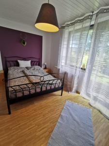 蒂蒂湖-新城Haus Buron的一间卧室配有一张床和紫色的墙壁