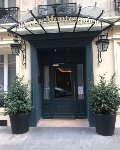 巴黎Hotel de Montesquieu的两棵盆栽植物的建筑物的前门