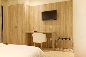 丹吉尔艾尔津尼纳酒店的一间卧室配有一张床,墙上配有电视