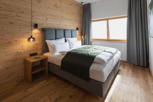 皮茨河谷阿兹尔Puitalm - Natur I Apart I Hotel的一间卧室设有一张带木墙的大床