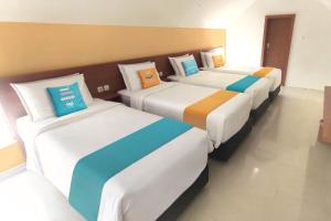 日惹Sans Hotel Pippo Yogyakarta by RedDoorz的一间房间里三张床的组合