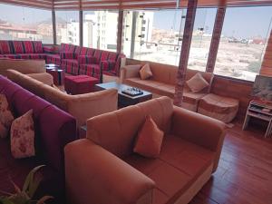 瓦迪穆萨Petra Cabin Inn Hostel&Resturant的带沙发、桌子和窗户的等候室