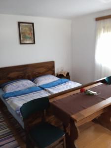 Brod na KupiKuća za odmor Lešnica的配有一张桌子和一把椅子的客房内的两张床