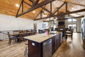 布兰森Beautiful Branson Lodge Close to All the Action的开放式厨房和用餐室设有木制天花板。