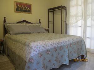 佩尼多Janela dos Meus Sonhos的一间卧室配有一张带花卉床罩的床