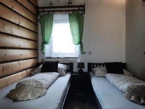 卢奇基Chalupa pri vodopade的带窗户的客房内设有两张单人床。