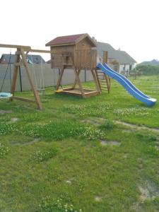 吉日茨科Domek u Ani的草地上带蓝色滑梯的游乐场