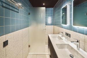 海尔许霍瓦德Hotel Babylon Heerhugowaard - Alkmaar的一间带两个盥洗盆和淋浴的浴室