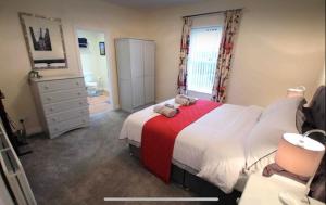 CullybackeyBallyconnelly Cottages, Galgorm area的一间卧室配有一张带红色毯子的大床