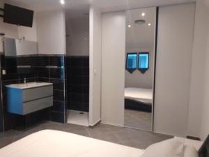 蒙达迪Villa Piscine的浴室设有床、水槽和镜子
