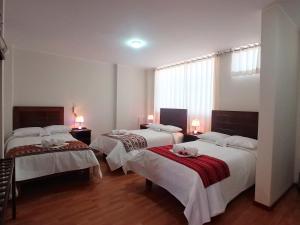 奇瓦伊Colca Canyon Hotel的一间卧室配有两张带白色床单和红色毯子的床。