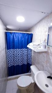 巴兰基亚Casa Boston Inn的浴室配有蓝色的浴帘和卫生间
