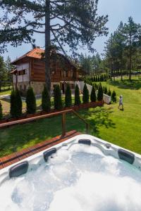 兹拉蒂博尔Mountain Villa Udovicic的一个带有房子的庭院内的热水浴池