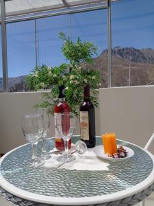 奇瓦伊Colca Canyon Hotel的一张桌子,上面放着两杯酒和一瓶葡萄酒