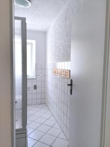 佩讷明德Usedoms Kleines Ostseeglück #1 in Peenemünde bis 4 Personen, Zuganreise möglich的带淋浴和门的白色瓷砖浴室