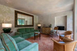 科莫The Greenhouse Luxury Villa on Lake Como的客厅配有绿色沙发和椅子