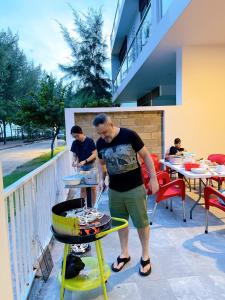 隆海Villa Zenna Long Hải - Mimosa 611 View Biển的露台上的烧烤架上的人做饭