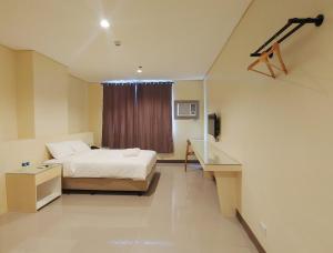 马尼拉Kaizen Suites的酒店客房设有床和窗户。