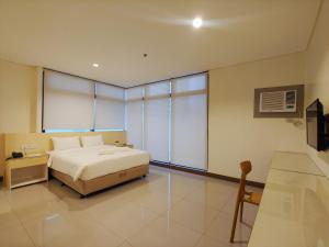 马尼拉Kaizen Suites的一间卧室设有一张床和一个大窗户
