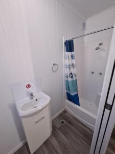 DulaccaThe Dulacca Hotel的白色的浴室设有水槽和淋浴。