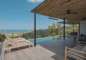 塞隆贝拉纳克DUNIA LOMBOK - Villas with Ocean View的一座别墅,设有游泳池和一个木制甲板