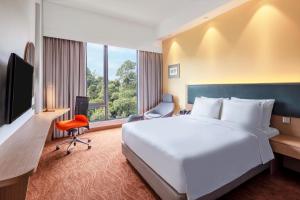哥打京那巴鲁Holiday Inn Express Kota Kinabalu City Centre, an IHG Hotel的一间酒店客房,设有一张大床和一个大窗户