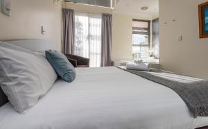 奥尔巴尼Seaview and Spa at Torbay的一间卧室配有一张带白色床单和蓝色枕头的大床。