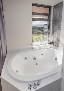 奥尔巴尼Seaview and Spa at Torbay的带窗户的浴室内的白色浴缸