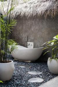 乌鲁瓦图Villa Amantes Bingin的带浴缸和盆栽植物的浴室