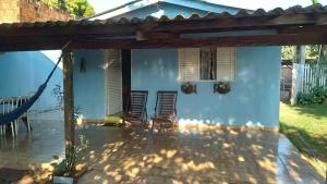 诺布里斯Casa Pedacinho do Céu的一个带椅子的庭院和蓝色的房子