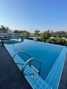 是拉差Christella Hotel Laemchabang的边缘带椅子的蓝色游泳池