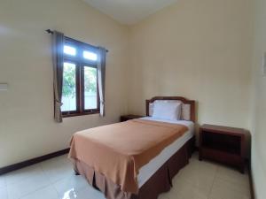 登巴萨Adi Pelita Sari Bali的一间卧室设有一张床和一个窗口
