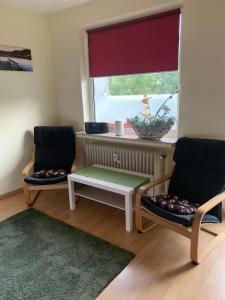 不莱梅Zentrales Apartement Bremen的窗户客房内的两把椅子和一张桌子