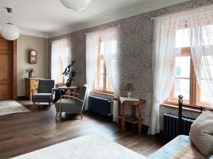 库尔迪加Apartamenti Kuldīgas Pilsdzirnavas的卧室设有2扇窗户和桌椅