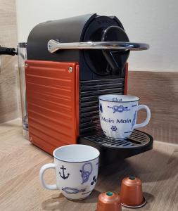 伯尔格伦德-雷特维施Appartement Mittsommer的桌子上带两个咖啡杯的烤面包机
