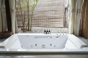 琅勃拉邦乐森精品酒店的窗户客房内的白色浴缸