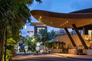 努沙杜瓦The Sakala Resort Bali All Suites的享有棕榈树建筑的夜间景色